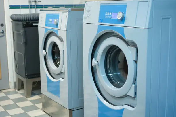 Commercial front-loading washers in a laundry facility, showcasing modern design and functionality, relevant to Appliance Repair Expert's washer repair services.