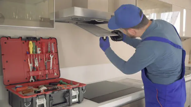Technician repairing kitchen appliance with tools in toolbox, emphasizing prompt and professional Cove Appliance Repair services in Toronto.