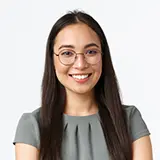 Smiling woman with long dark hair and glasses, wearing a gray blouse, representing satisfied customers of Appliance Expert, highlighting positive service experiences.