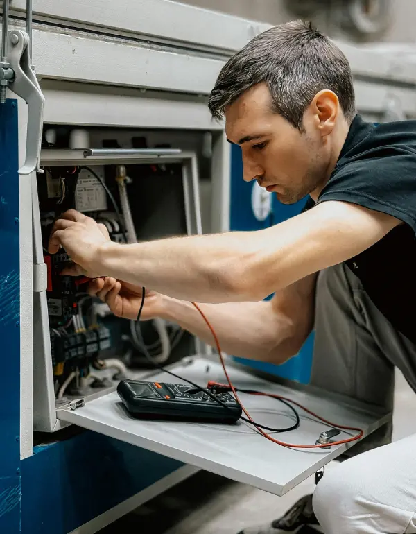 Technician repairing Samsung dishwasher, inspecting internal components and using multimeter for diagnostics, emphasizing professional leak repair services in Toronto.