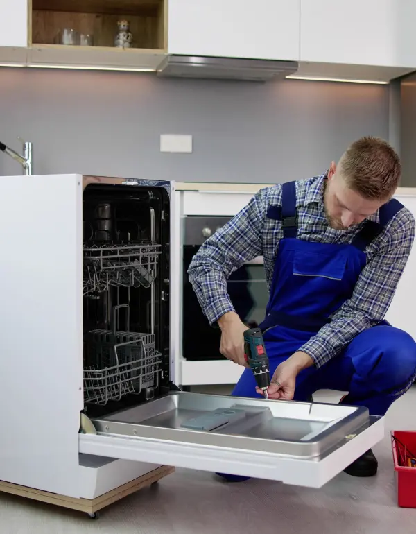 Technician repairing a Samsung dishwasher in a modern kitchen, focused on diagnosing and fixing a leak issue, emphasizing appliance repair services in Toronto.