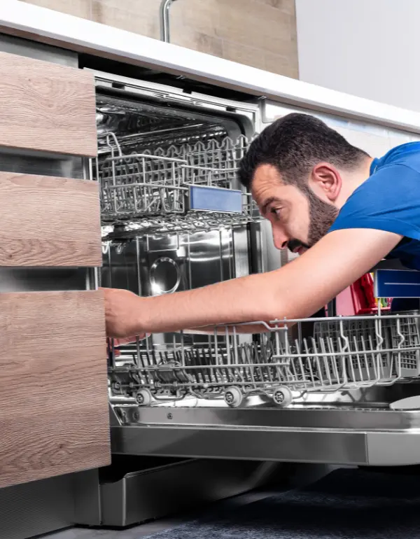 Technician inspecting Samsung dishwasher during repair service in modern kitchen setting.